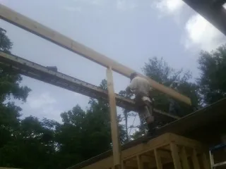 Carpenter setting a ridge beam over a new addition frame — Ice Dam Removal by Roofing Brothers in Middlebury Center