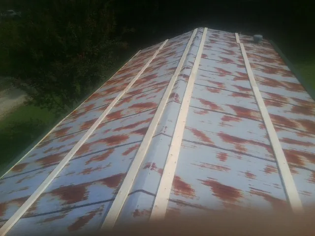 Rusted metal roof panels with new wood purlins before replacement — Storm Damage Roof Repair in Middlebury Center by Roofing Brothers