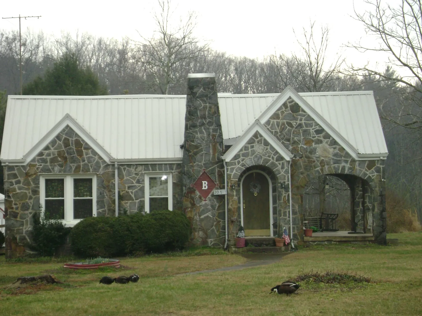 White metal roof on a stone cottage with steep gables in Middlebury Center