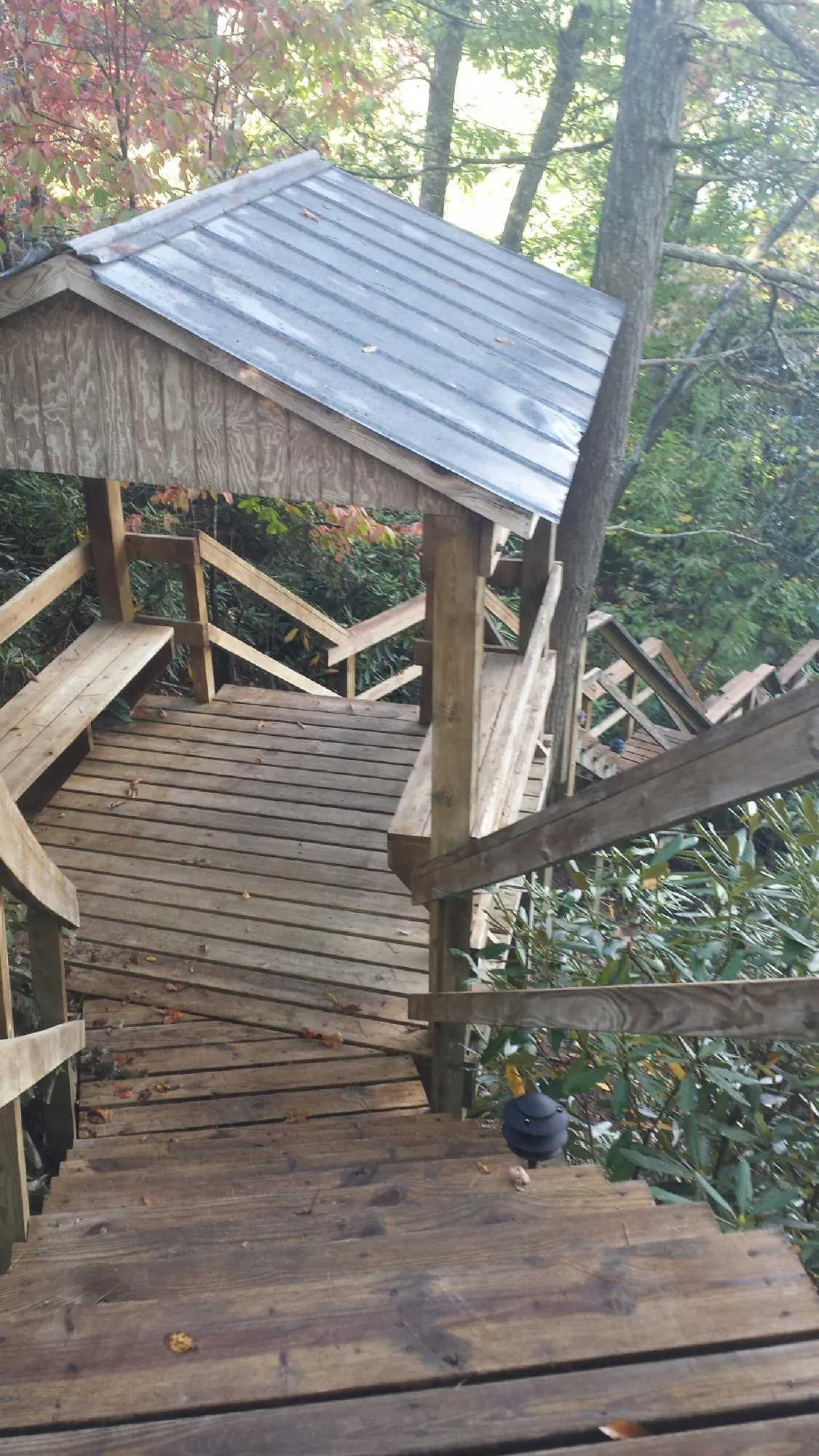 Metal roofed shelter over wooden steps on a wooded walkway — Skylight Repair & Installation work by our crew in Middlebury Center
