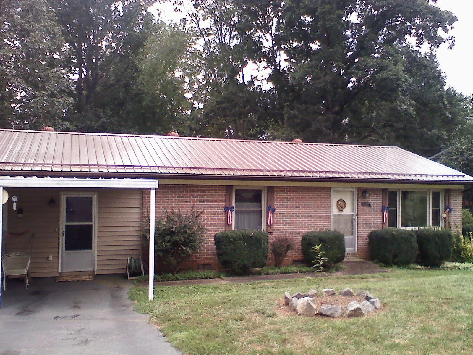 Bronze metal roof and carport on a brick ranch home — Roof Repair work by our crew in Middlebury Center