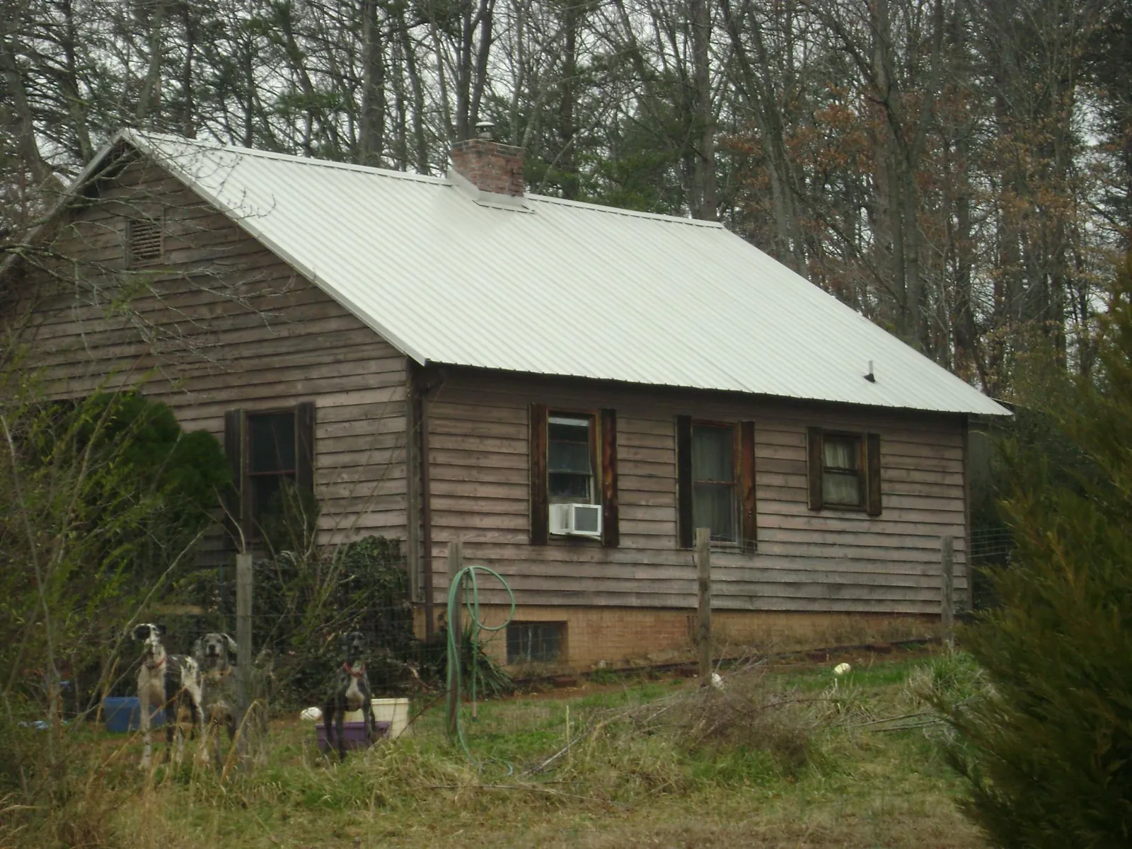 White metal roof on an old wood sided farmhouse, from a Metal Roof Installation job in Middlebury Center